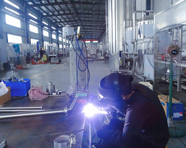 Industrial welding scene with worker and equipment